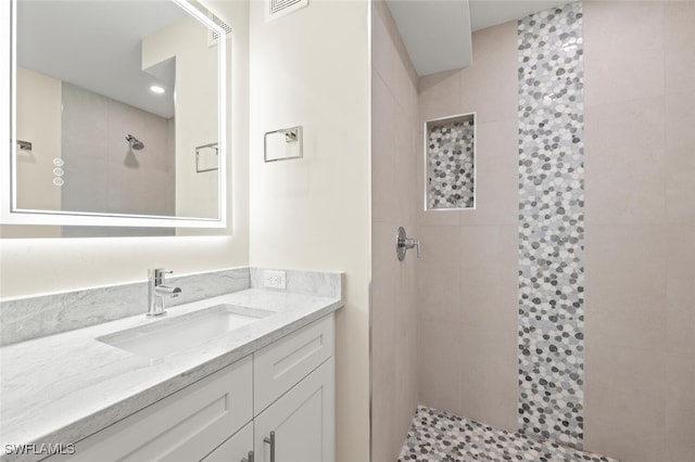 full bathroom with a walk in shower, visible vents, and vanity