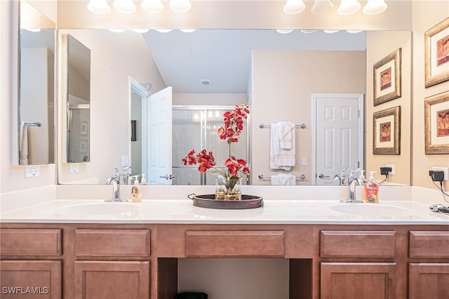 bathroom featuring a shower with door and vanity