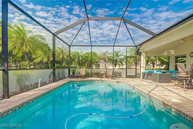 view of swimming pool with ceiling fan, a lanai, an outdoor hangout area, and a patio area