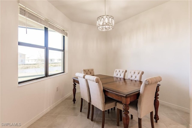 dining area with a healthy amount of sunlight, light tile patterned flooring, and a chandelier