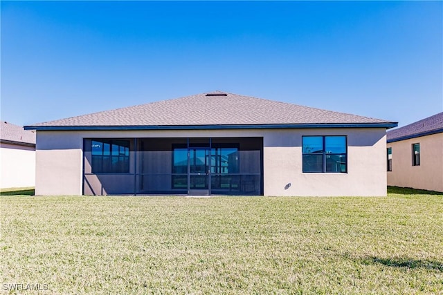 back of house featuring a lawn and a sunroom