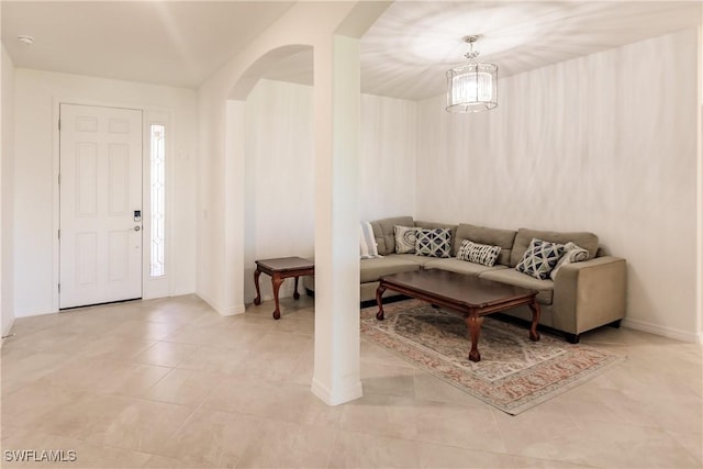 tiled living room featuring an inviting chandelier