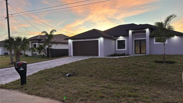 view of front of home with a garage and a yard