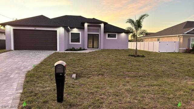 view of front of property with a yard and a garage