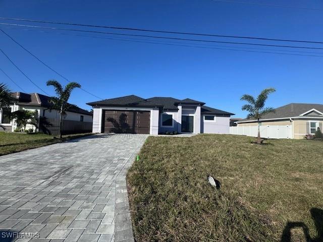 view of front of property featuring a garage and a front lawn