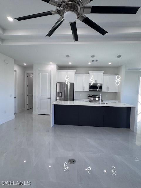 kitchen with white cabinetry, ceiling fan, stainless steel appliances, a spacious island, and decorative light fixtures