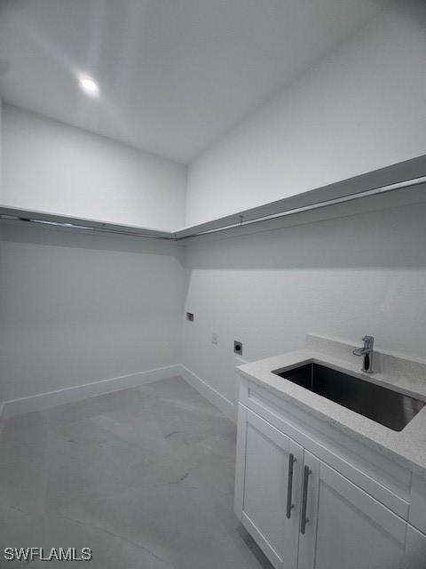 laundry area featuring hookup for an electric dryer, cabinets, and sink