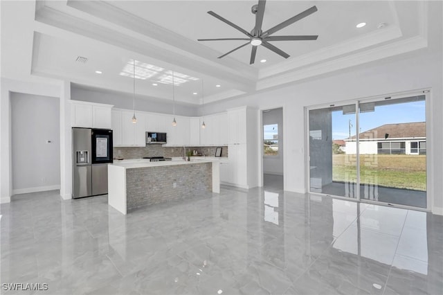 kitchen with ceiling fan, white cabinetry, stainless steel appliances, and an island with sink