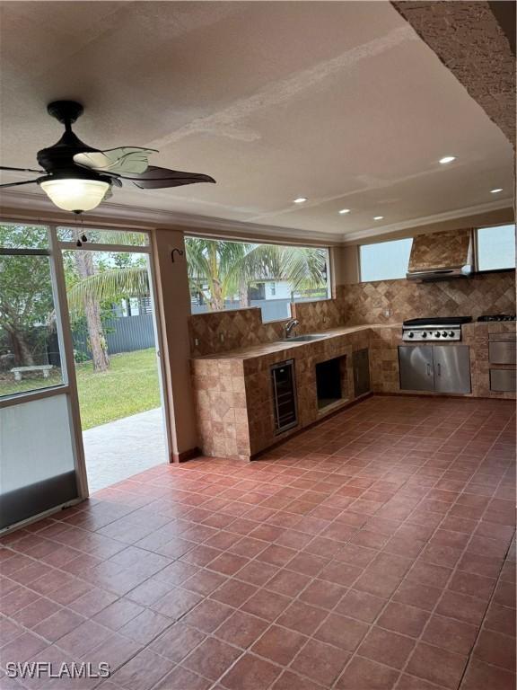 view of patio with ceiling fan, area for grilling, and beverage cooler