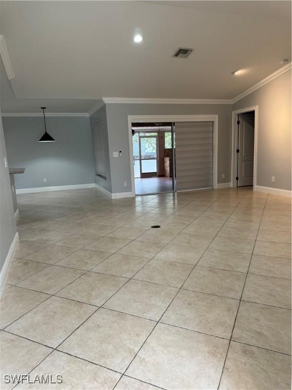 tiled spare room featuring ornamental molding