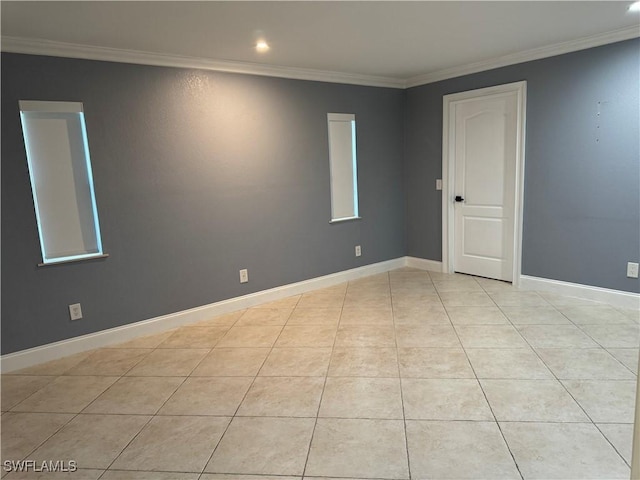 tiled empty room featuring crown molding