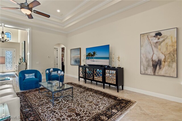 living room featuring a high ceiling, ceiling fan with notable chandelier, a tray ceiling, and crown molding