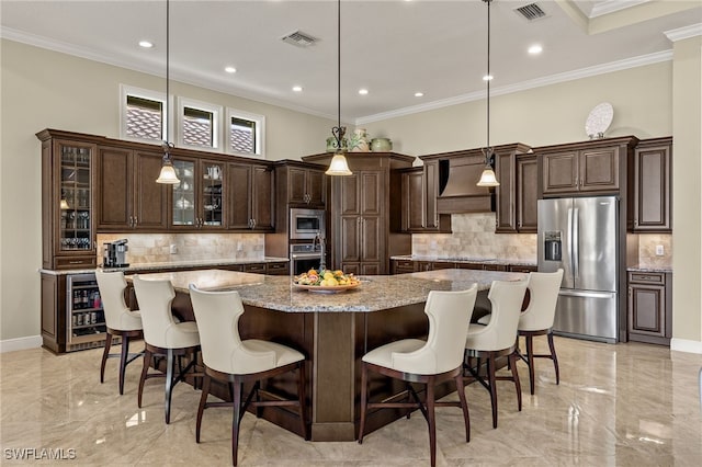 kitchen with a large island, stainless steel appliances, light stone countertops, decorative light fixtures, and custom exhaust hood