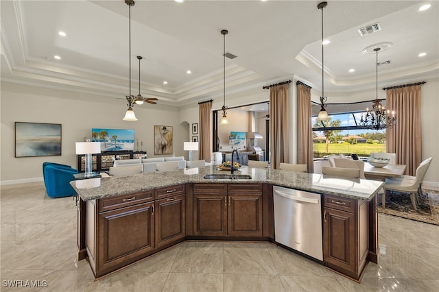 kitchen with a raised ceiling, a center island with sink, stainless steel dishwasher, and sink