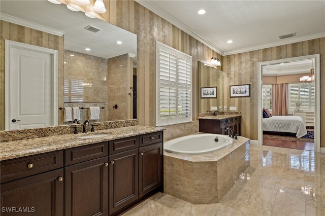 bathroom with a notable chandelier, vanity, ornamental molding, and tiled bath