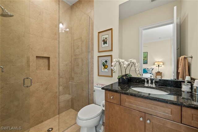 bathroom featuring vanity, toilet, and an enclosed shower