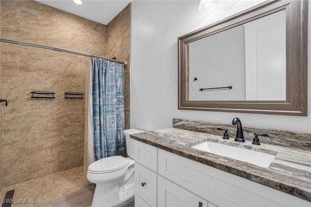 bathroom featuring toilet, a shower with shower curtain, and vanity