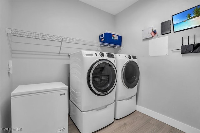 washroom featuring light hardwood / wood-style floors and washer and clothes dryer