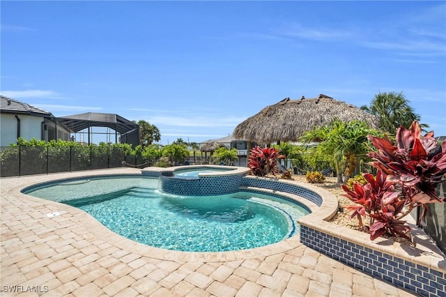 view of swimming pool featuring an in ground hot tub and a patio