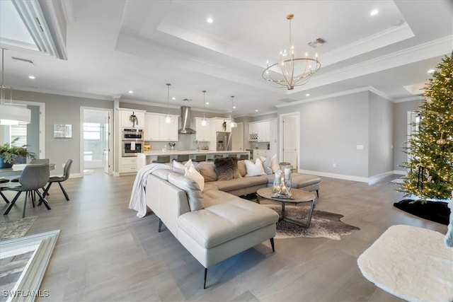 living room featuring a notable chandelier, crown molding, and a raised ceiling