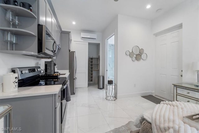 kitchen with appliances with stainless steel finishes, gray cabinetry, and an AC wall unit