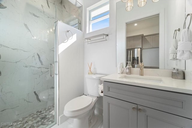 bathroom with toilet, a shower with door, and vanity