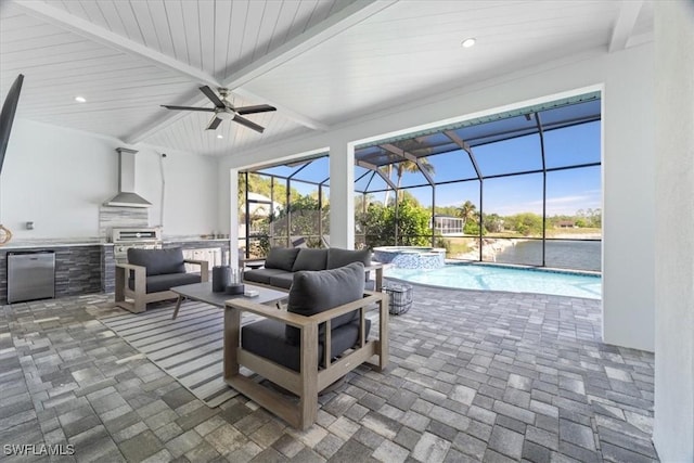 view of patio / terrace with a pool with hot tub, glass enclosure, outdoor lounge area, and exterior kitchen