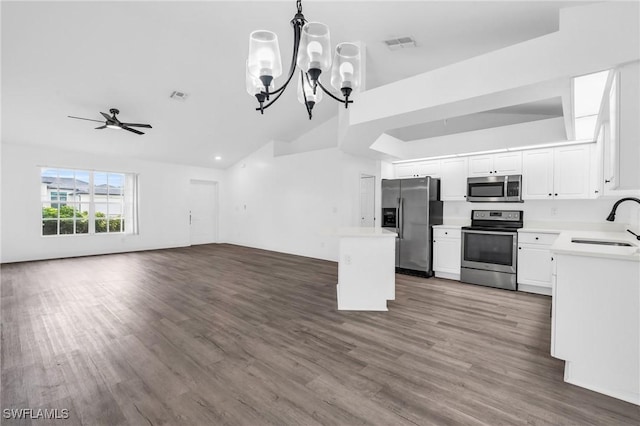 kitchen featuring appliances with stainless steel finishes, decorative light fixtures, dark hardwood / wood-style flooring, sink, and white cabinetry