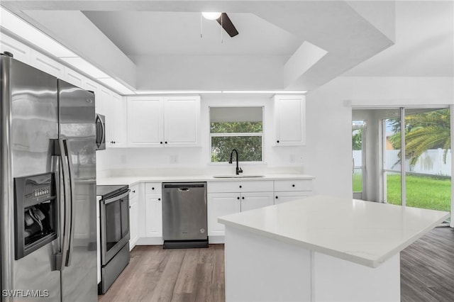 kitchen featuring light wood-type flooring, sink, ceiling fan, appliances with stainless steel finishes, and white cabinets