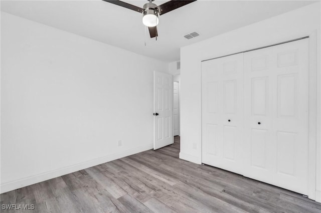 unfurnished bedroom with light wood-type flooring, a closet, and ceiling fan