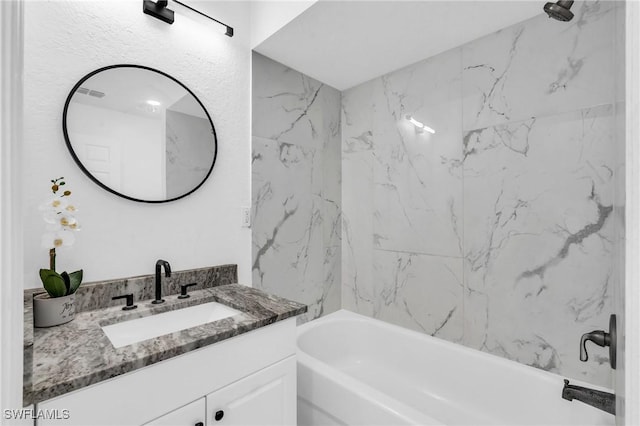 bathroom featuring tiled shower / bath combo and vanity