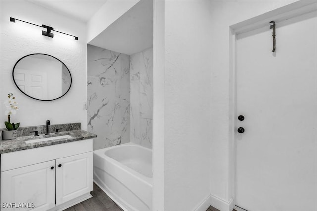 bathroom with vanity, tiled shower / bath, and hardwood / wood-style floors