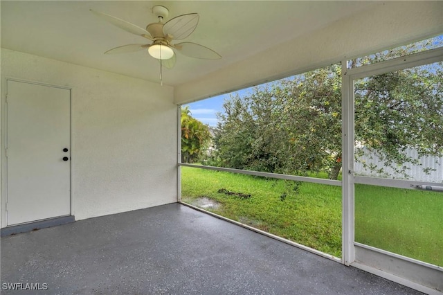 unfurnished sunroom with ceiling fan