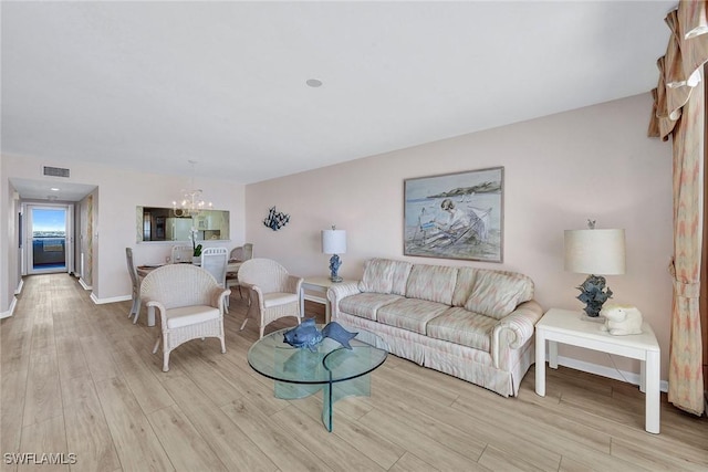 990 Cape Marco Dr Unit 1102, Marco Island, FL 34145 - living area with a chandelier, light wood finished floors, and baseboards