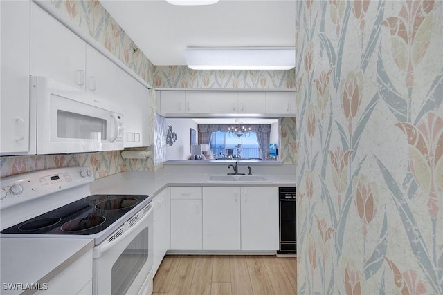 kitchen with white cabinets, white appliances, light hardwood / wood-style floors, and sink