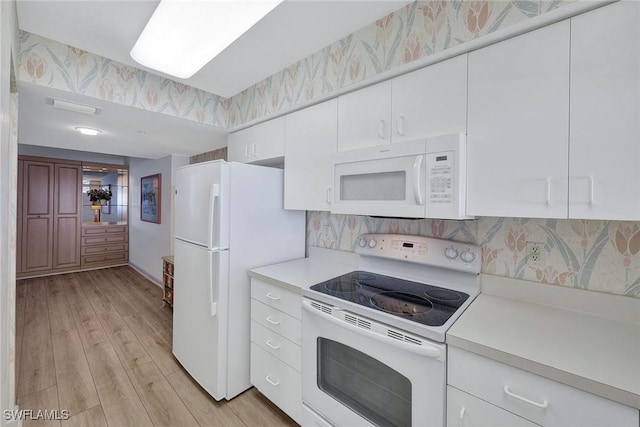 kitchen featuring white cabinets, white appliances, and light wood-type flooring