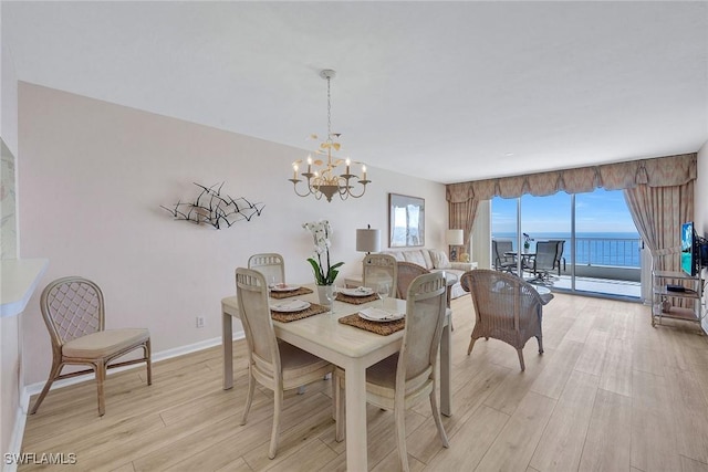 990 Cape Marco Dr Unit 1102, Marco Island, FL 34145 - dining room featuring light wood-style floors, a chandelier, and baseboards