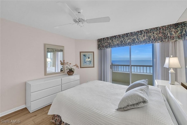 bedroom with ceiling fan, light hardwood / wood-style floors, and a water view