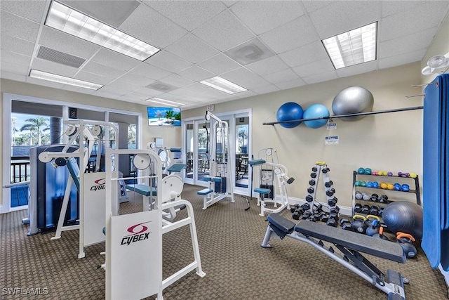 gym featuring carpet flooring and a drop ceiling