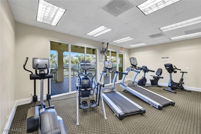 workout area with carpet flooring and a paneled ceiling