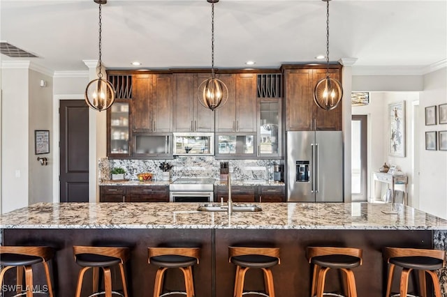 kitchen with a breakfast bar, backsplash, decorative light fixtures, and high quality fridge