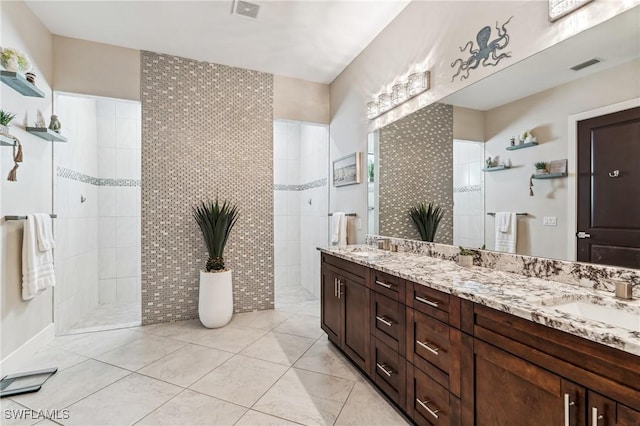 bathroom featuring a tile shower, tile patterned floors, vanity, and tile walls