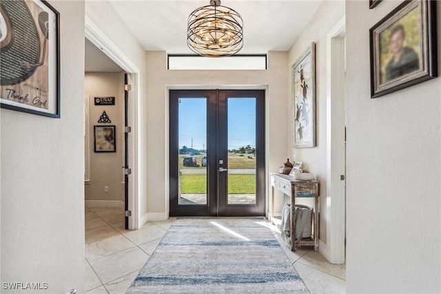 doorway with french doors, light tile patterned floors, and a notable chandelier