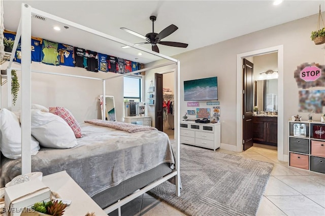 bedroom with a walk in closet, ensuite bath, ceiling fan, light tile patterned flooring, and a closet