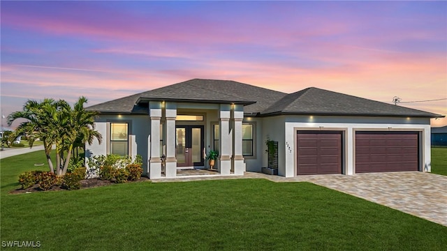 prairie-style home with a garage and a lawn