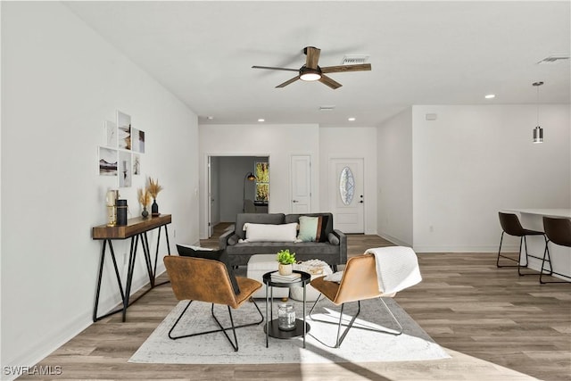 living room with ceiling fan and light wood-type flooring