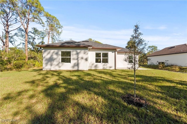 rear view of house featuring a yard