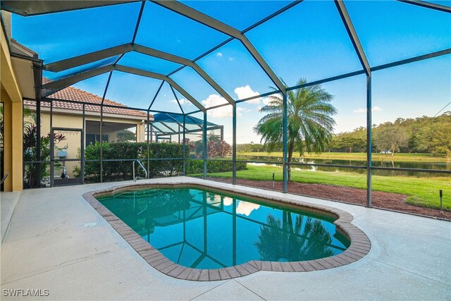 view of pool with a patio, a water view, and glass enclosure