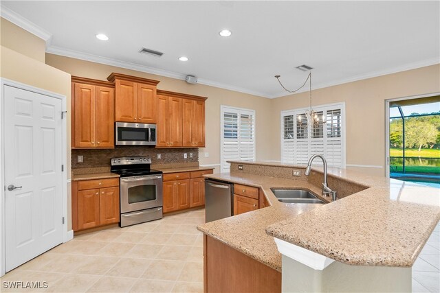 kitchen with stainless steel appliances, crown molding, sink, a center island with sink, and an inviting chandelier