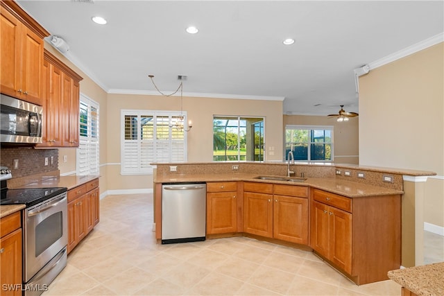 kitchen featuring sink, stainless steel appliances, light stone counters, crown molding, and ceiling fan with notable chandelier